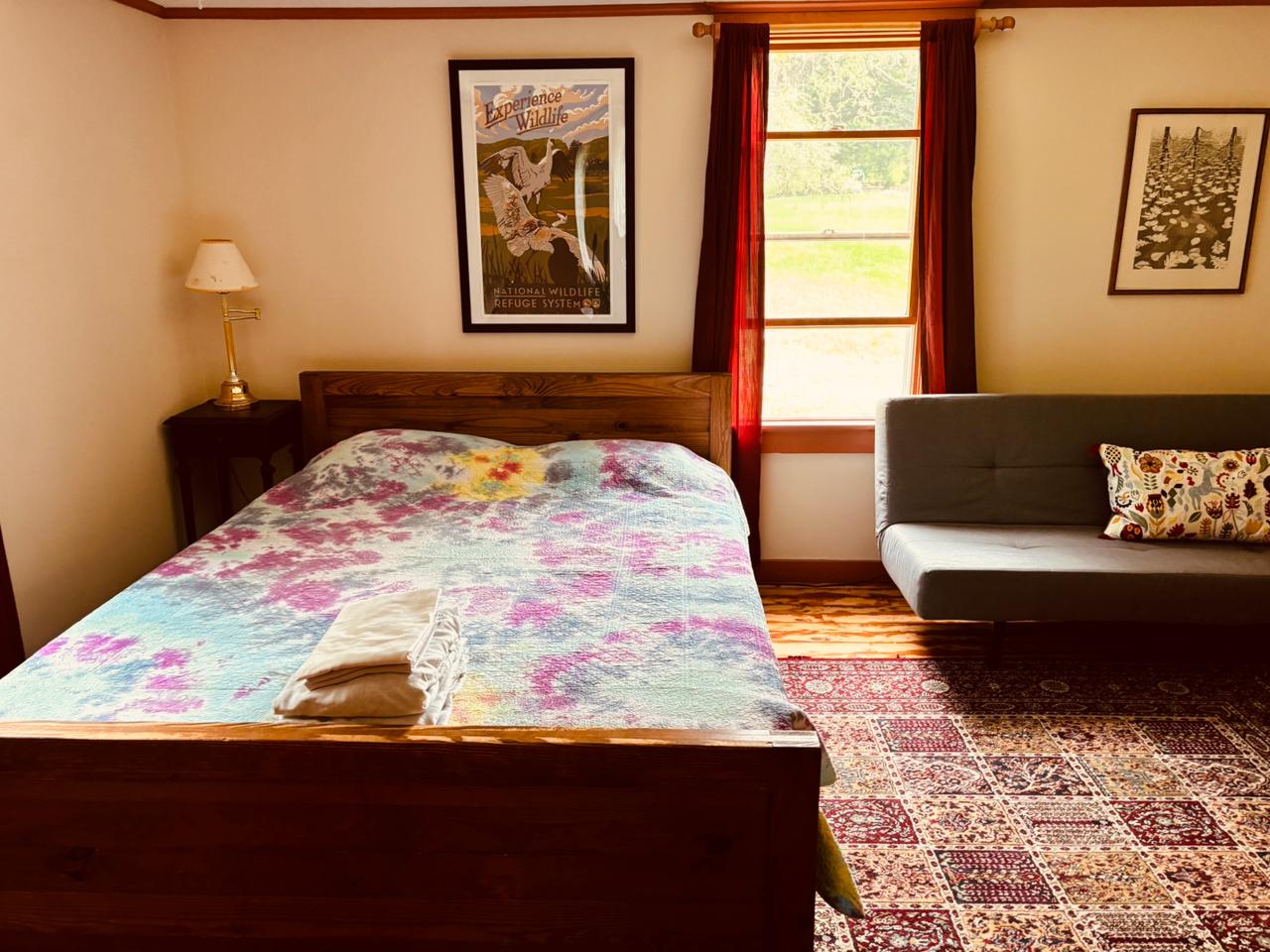 Bed with tie-dye comforter and wildlife poster