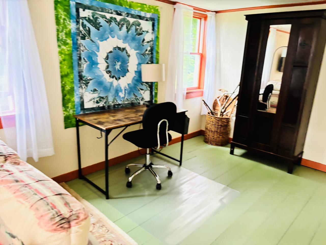 Bedroom with desk and dark armoire